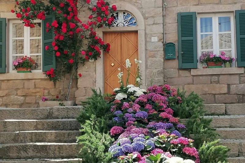 Casa in pietra nel centro storico di Aggius con balconi e fiori in Gallura